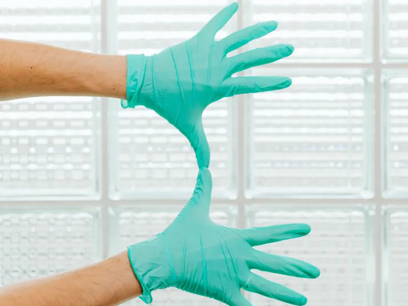 Technician putting on protective gloves before a treatment
