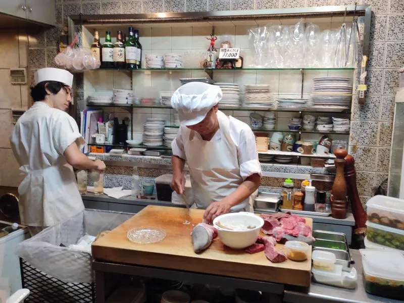 Chefs working in a busy commercial kitchen that needs pest control contracts